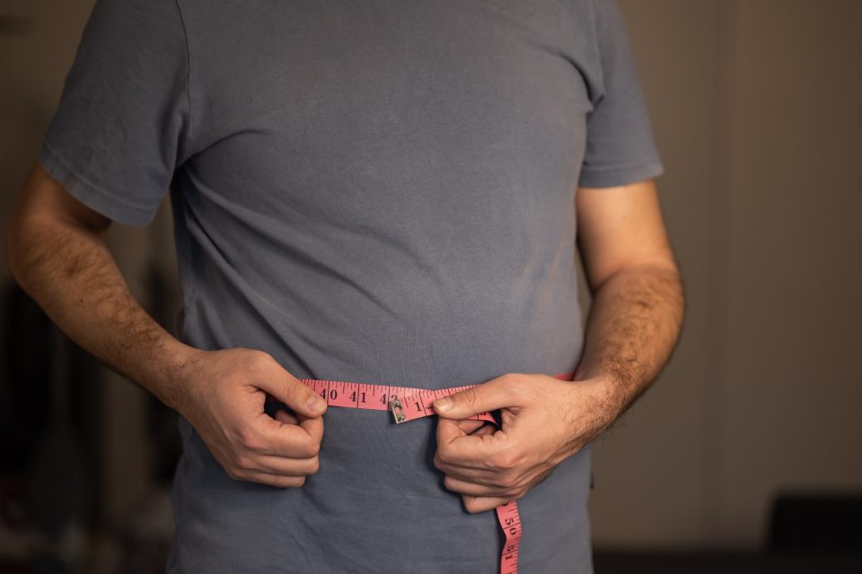 man measuring his stomach